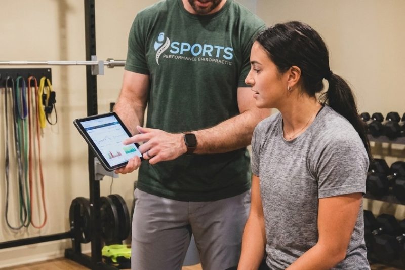 Provider reviewing movement screen and VALD testing data with an athlete at a sports performance chiropractic clinic in Southern Pines, NC